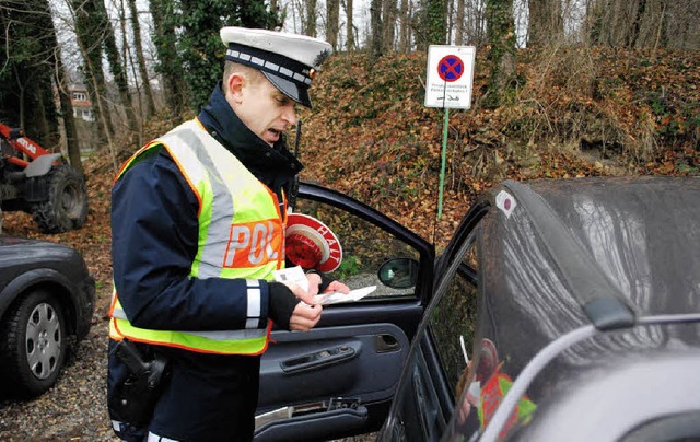 Die Polizisten winken die Verkehrssnd...Daten auf und schreiben eine Anzeige.   | Foto: Mink