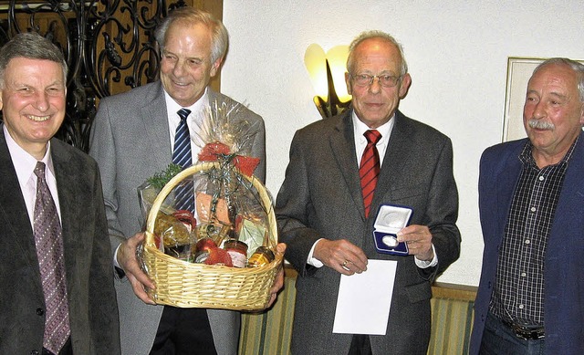 Die Vorstandsmitglieder Karlpeter Schm... die Auszeichnungen und ein Geschenk.   | Foto: Baugenossenschaft