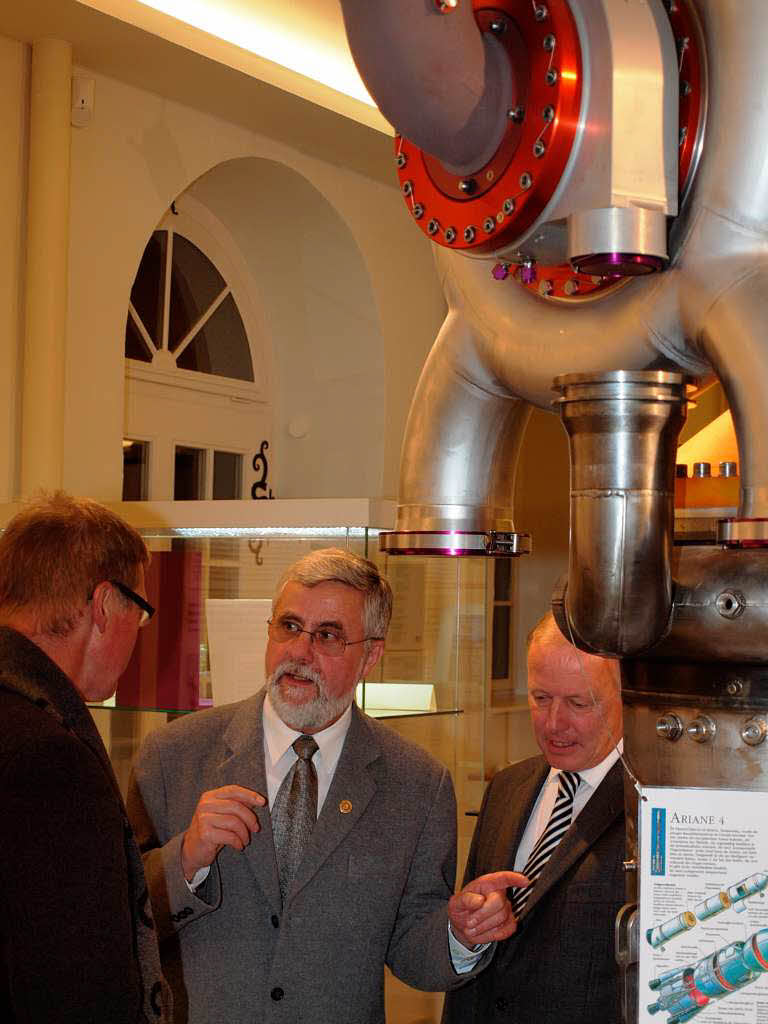 Geschichtsvereinsvorsitzender Peter Ziegeler (Mitte) erklrt Erffnungsgsten das Ariane-Triebwerk