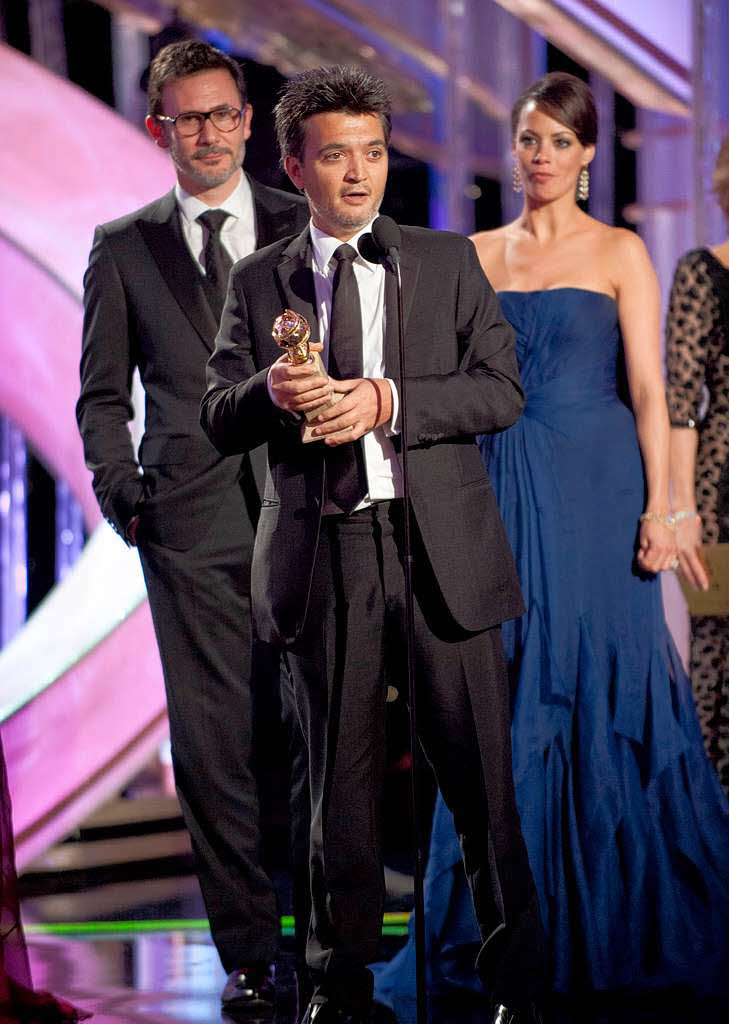 Der franzsische Produzent Thomas Langmann (M) empfngt en Golden Globein der Kategorie Komdie fr „The Artist“. Hinter ihm: der Regisseur  Michel Hazanavicius und dessen Frau und Hauptdarstellerin Berenice Bejo.