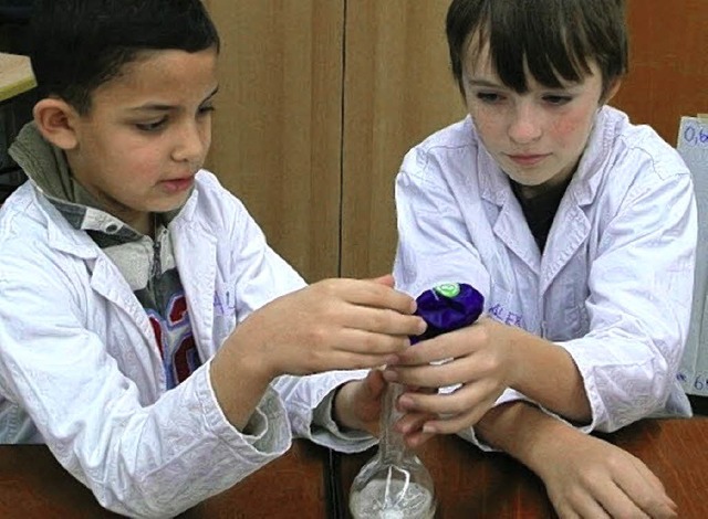 Ali (9) und Alexander (10) schtten vo...n, wie das  Gas Kohlendioxid entsteht.  | Foto: Kirsten Lux