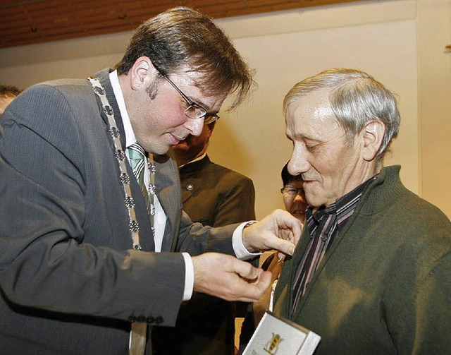 Brgermeister Carsten Gabbert (rechts) heftet Adolf Gppert die Ehrennadel an.  | Foto: h. fssel