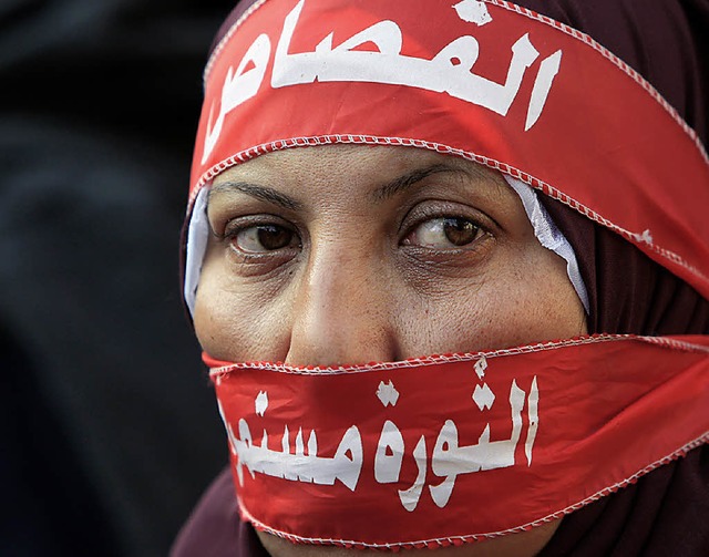 &#8222;Die Revolution geht weiter&#822...uf dem Stirnband dieser Demonstrantin.  | Foto: AFP