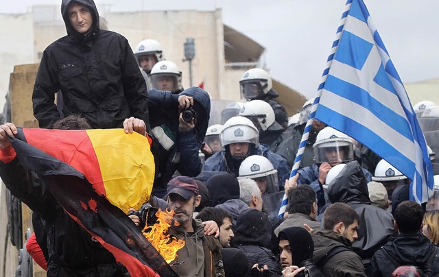 Griechische Demonstranten verbrennen in Athen  eine deutsche Flagge.   | Foto: DPA