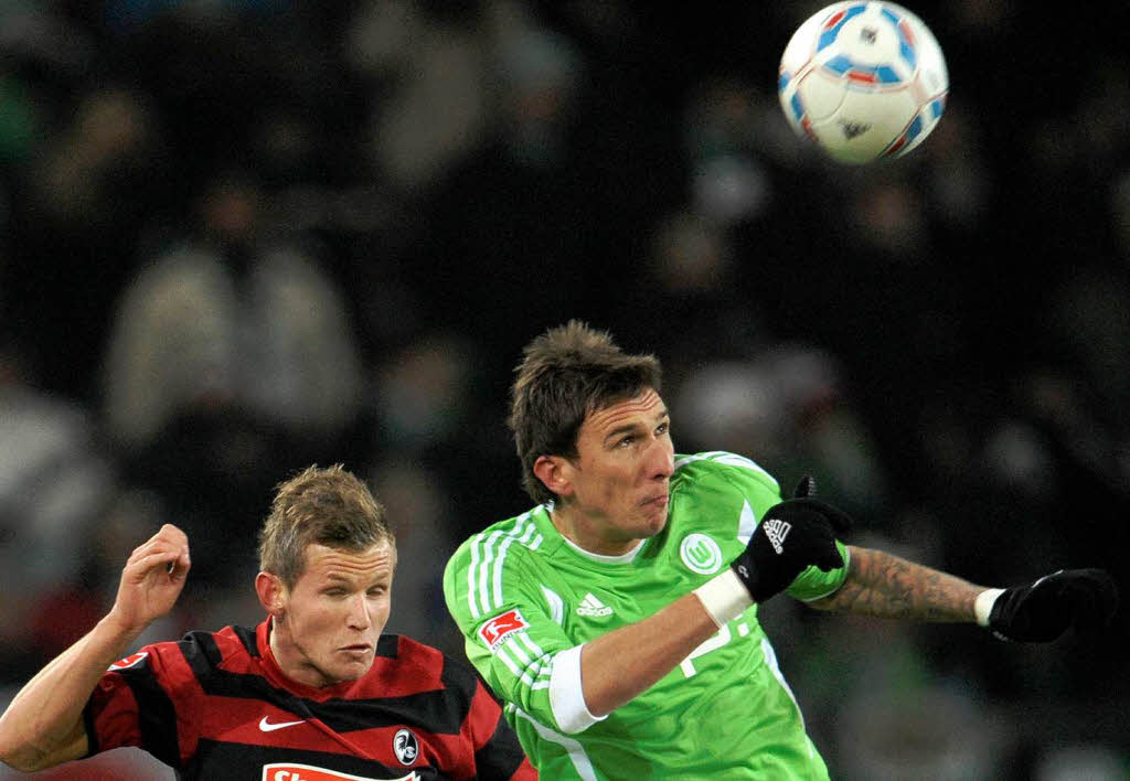 Der Wolfsburger Mario Mandzukic (r) und der Freiburger Spieler Jonathan Schmid kmpfen um den Ball.
