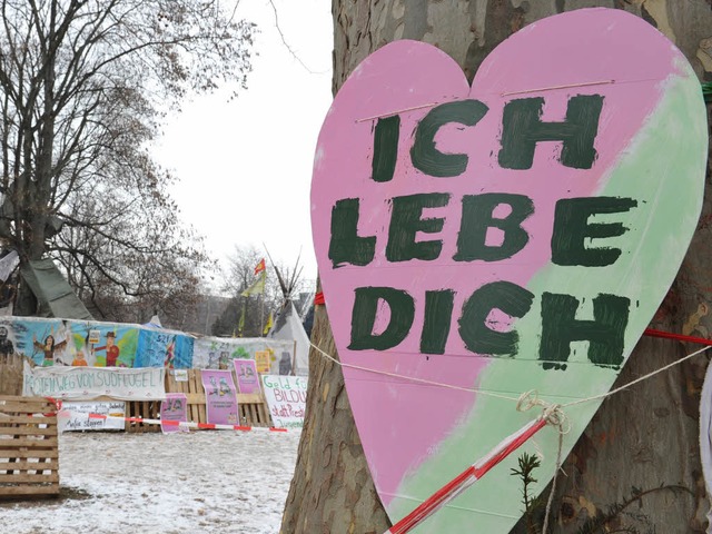 Ein herzfrmiges Schild mit der Aufsch... in Stuttgart an einem Baum befestigt.  | Foto: dpa