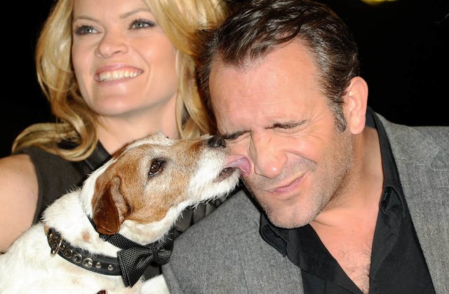 Der Schauspieler Jean Dujardin bekommt einen Kuss von Uggie.   | Foto: afp