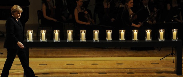 Zwlf Kerzen brennen bei der Gedenkfei...emeinsame Hoffnung und die Zuversicht.  | Foto: DPA