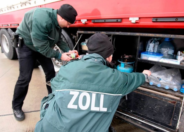 Zwei Beamte durchsuchen am Zollbergang in Konstanz am Bodensee einen Lastwagen.  | Foto: Verwendung weltweit, usage worldwide