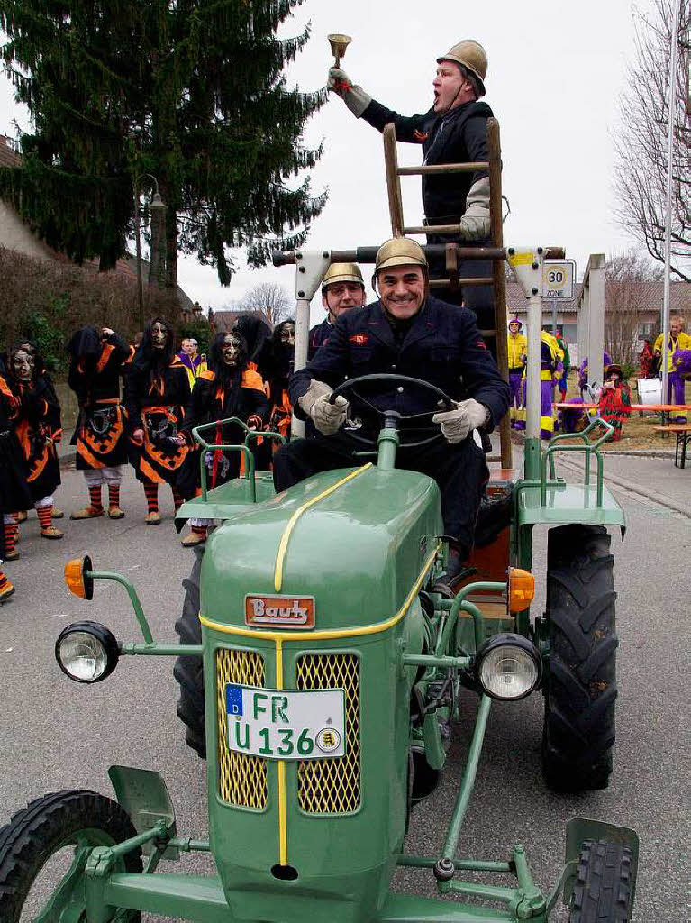 Schallstadter Feuerwehrmnner in historischen Uniformen auf einem Odtimer-Traktor beim Jubilumsumzug der Wolfszunft.