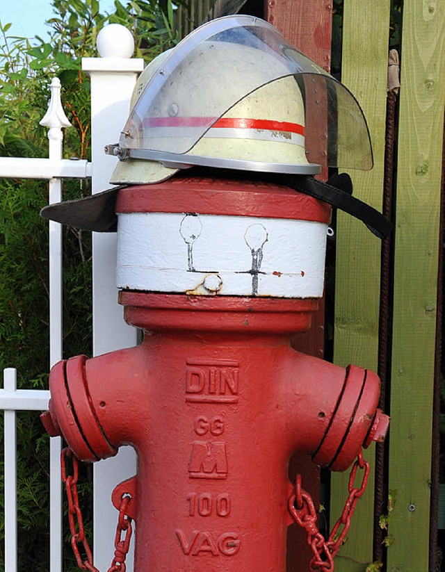 Zwei Symbole fr wehrhafte Feuerwehr: Hydrant und Helm.  | Foto: DPA