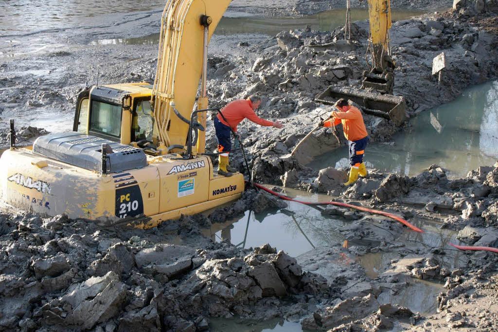 Bergungsversuche am versunkenen Spezialbagger am Freitag: Bauhotfmitarbeiter installieren eine Schmutzwasserpumpe. Bergungsversuche am versunkenen Spezialbagger am Freitag: Bauhotfmitarbeiter installieren eine Schmutzwasserpumpe.