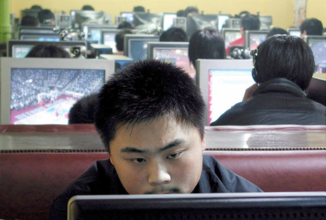 Ein Mann sitzt in einem Internetcaf in Qingdao in China vor einem Computer.   | Foto: dpa