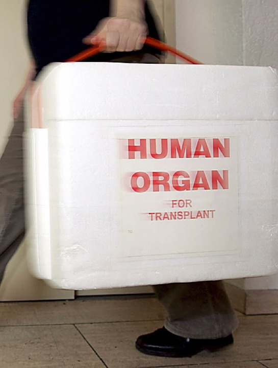 Eine Mitarbeiterin der Stiftung trägt eine Kühlbox für Spenderorgane.   | Foto: DPA