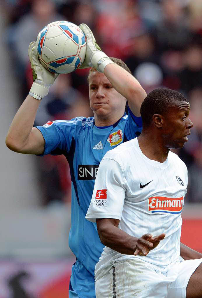 Bayer-Torwart Leno pflckt den Ball herunter, Karim Guede dreht ab.
