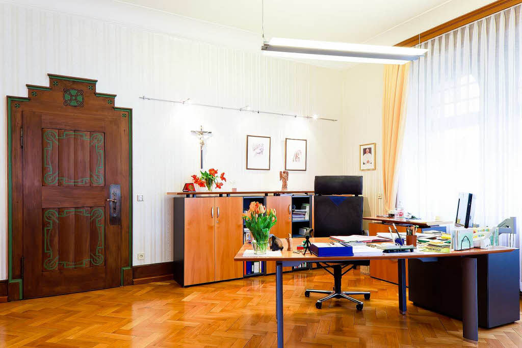 "In diesem Bro arbeite ich seit Juni 2003. Bei meinem Einzug wurde das  zuvor dunkle Mobiliar durch helleres ersetzt. Ein Gegenstand, der mir besonders viel bedeutet, ist die Figur eines Posaunenengels vom Freiburger Mnster. Gerne beobachte ich vom Bro-Fenster aus, wie die Sonne ber den Schlossberg wandert."