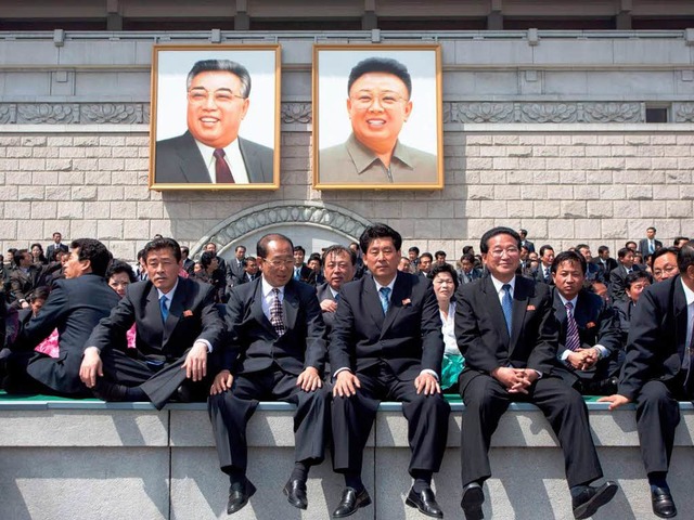 Menschen sitzen in Pjngjang vor den P...en 100. Geburtstag von Kim Il-Sung zu.  | Foto: AFP