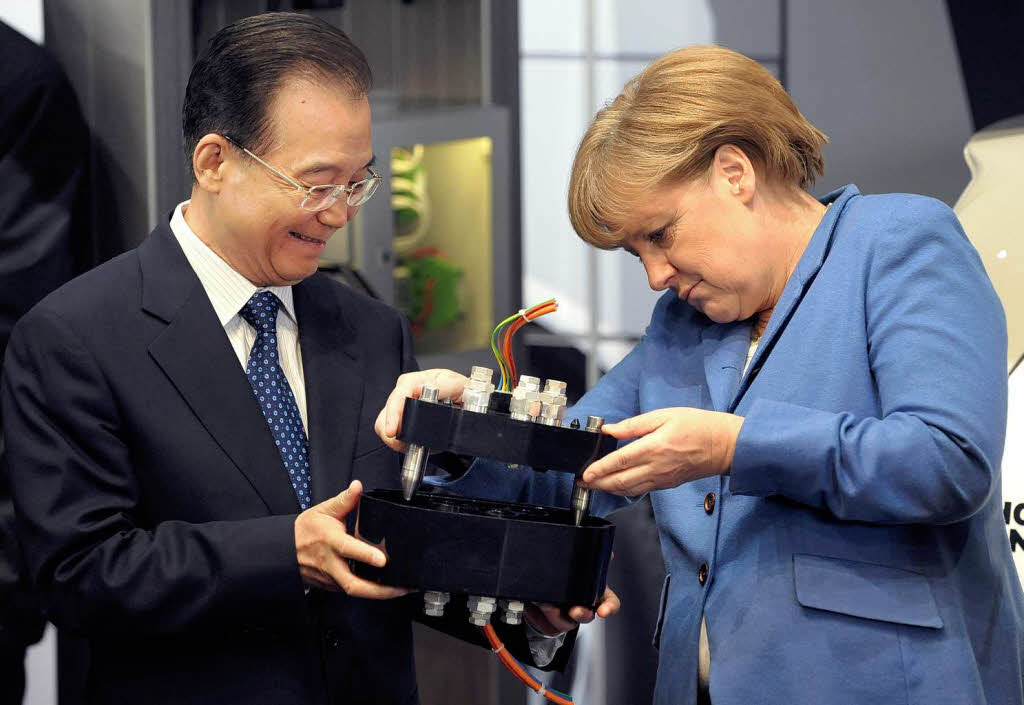 Bundeskanzlerin Angela Merkel (CDU) und der chinesische Ministerprsident Wen Jiabao halten auf dem Messegelnde in Hannover anlsslich der Erffnung der Messe eine elektrische Steckverbindung in den Hnden.