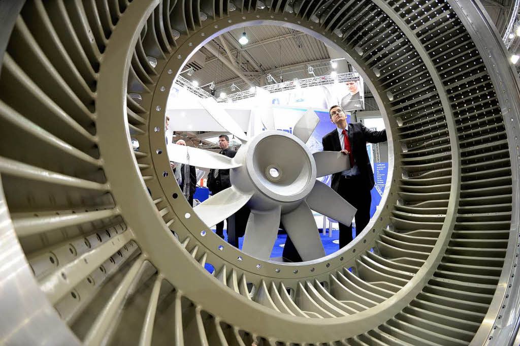 Ein Besucher betrachtet  auf dem Messegelnde in Hannover auf der weltgrten Industrieschau einen Aluguss-Rotor von einer zwei Megawatt Windkraftanlage.