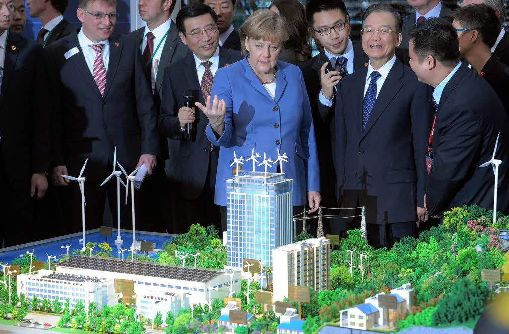Bundeskanzlerin Angela Merkel und der chinesische Ministerprsident Wen Jiabao (3.v.r.) betrachten auf dem Messegelnde in Hannover anlsslich der Erffnung der Messe das Modell einer Wohnanlage mit Windgeneratoren auf dem Dach.