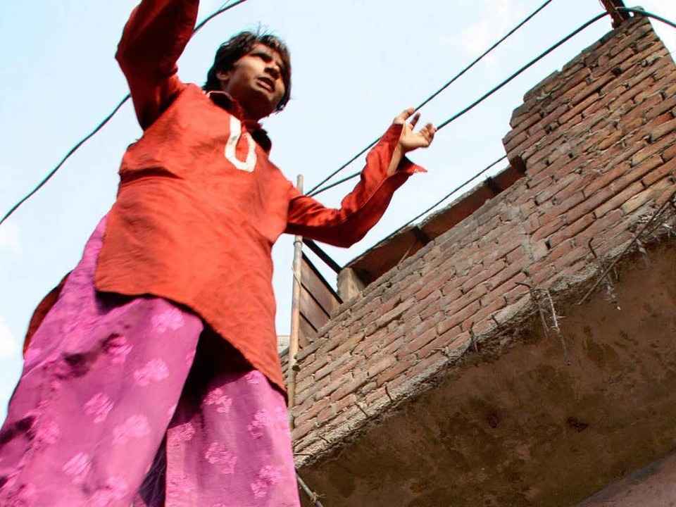 Ein Stelzenl�ufer aus der Kathputli Co... Neu Delhi posiert vor seinen Freuden.  | Foto: dpa