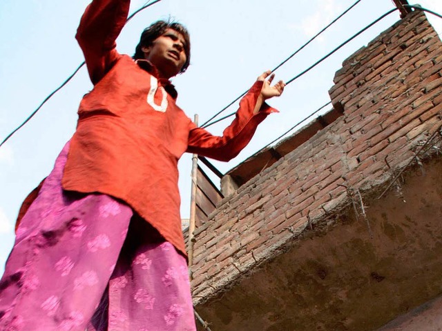 Ein Stelzenlufer aus der Kathputli Co... Neu Delhi posiert vor seinen Freuden.  | Foto: dpa