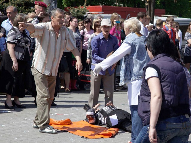 Passanten helfen einem Menschen, der v... Dnjepropetrowsk verletzt worden ist.   | Foto: dapd