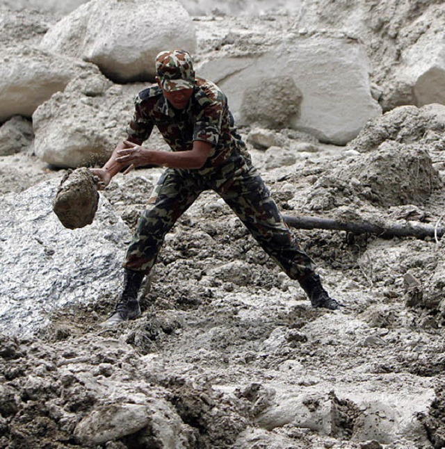 Ein Soldat sucht am Fluss Seti nach Opfern.   | Foto: dapd