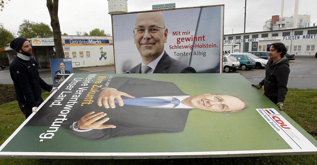 Symbolisch: Die CDU baut ihre Wahlplak... Torsten Albig lchelt dahinter noch.   | Foto: dapd