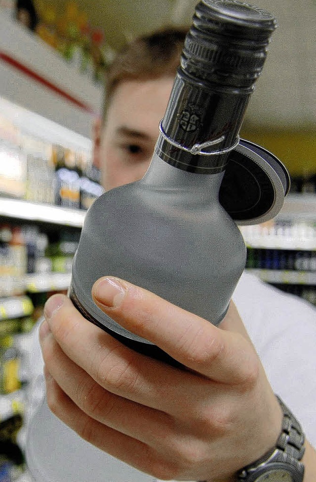 Versuchung Alkohol: In einer gestellte...regal eine Flasche Wodka in der Hand.   | Foto: DAPD
