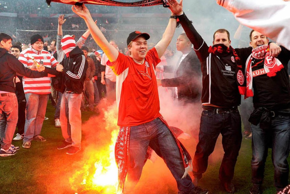 Die Partie in der Esprit-Arena stand in der Nachspielzeit am Rande des Abbruchs, weil Hunderte von Fans auf den Rasen gestürmt waren. (Foto: AFP) Die Partie in der Esprit-Arena stand in der Nachspielzeit am Rande des Abbruchs, weil Hunderte von Fans auf den Rasen gestürmt waren. (Foto: AFP)