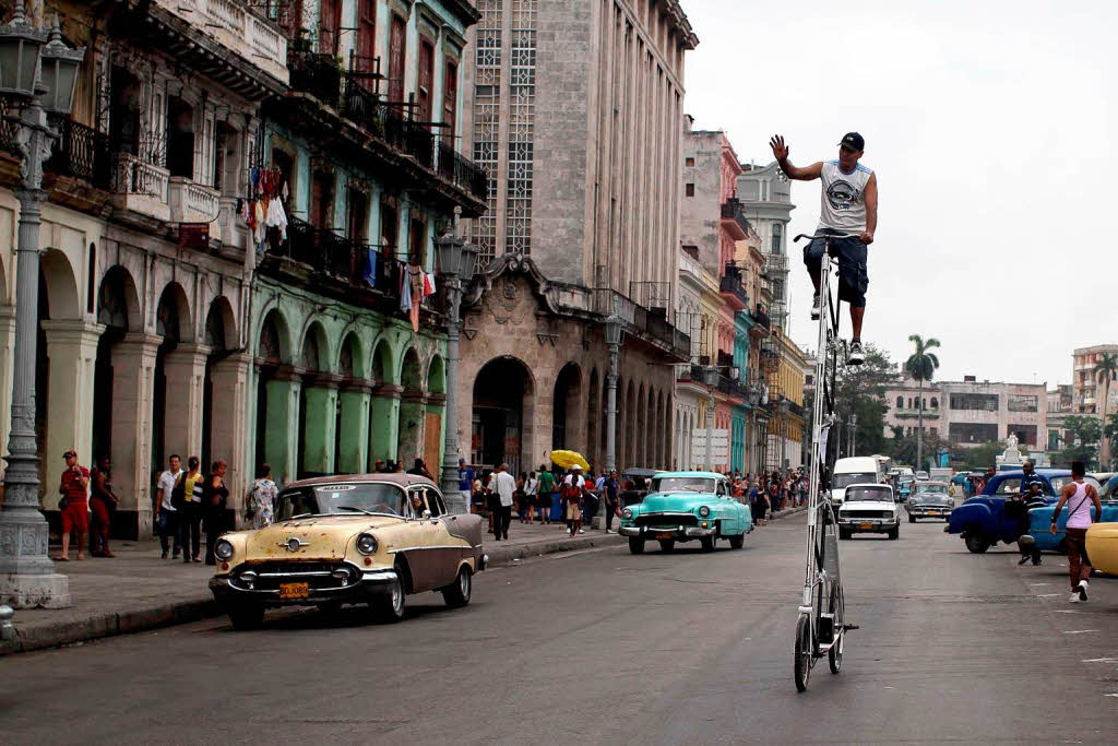 Felix Girola radelt fröhlich auf seinem mehr als fünf Meter hohem Fahrrad durch die Stadt Havanna in Kuba. Felix Girola radelt fröhlich auf seinem mehr als fünf Meter hohem Fahrrad durch die Stadt Havanna in Kuba.
