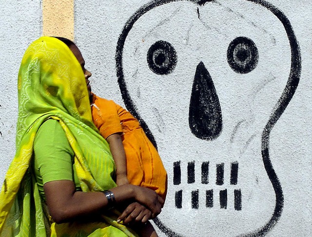 Frau im indischen Bhopal: Hinter der Mauer verbirgt sich die Giftfabrik.   | Foto: AFP