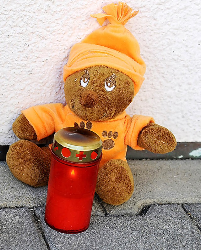 Ein Teddybr und eine Kerze stehen am ...vor dem Haus der Familie in Aldingen.   | Foto: dapd