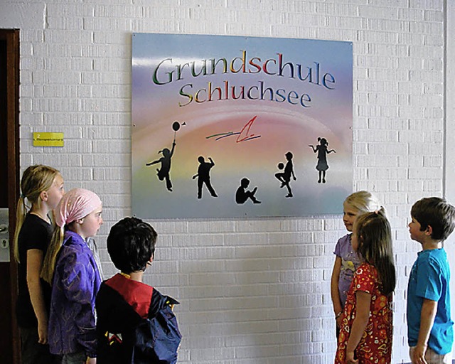 Kinder vor dem neuen Logo der Grundschule.   | Foto: T. Httich