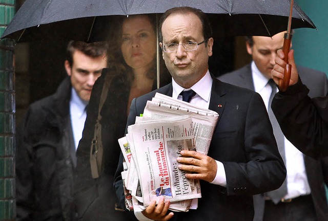 Frankreichs Prsident Francois Hollande am Wahltag mit seiner Zeitungslektre.   | Foto: dapd