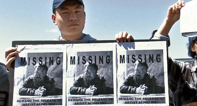 Ein chinesischer Demonstrant mit einem Flyer von AiWeiwei   | Foto: dpa