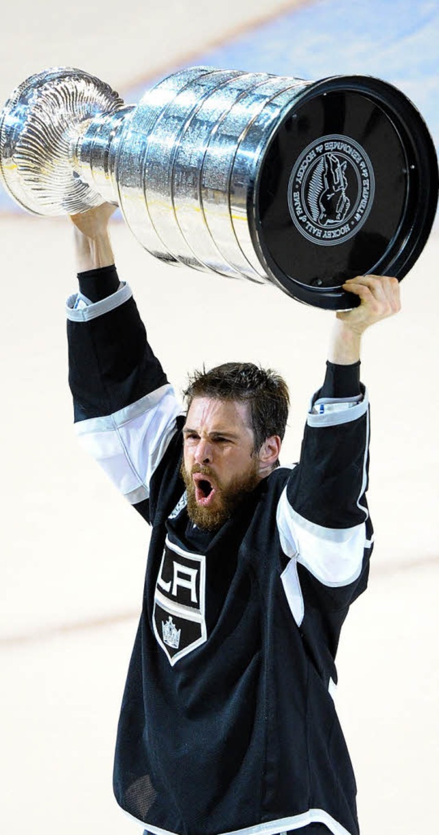 Willie Mitchell stemmt den Stanley Cup...die  wichtigste Trophe im Eishockey.   | Foto: AFP