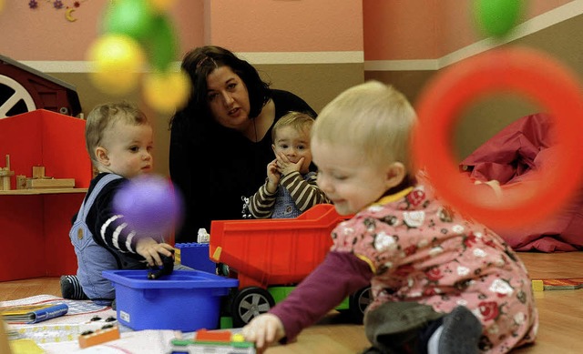 Eine Tagesmutter spielt mit den Kindern.    | Foto: DPA