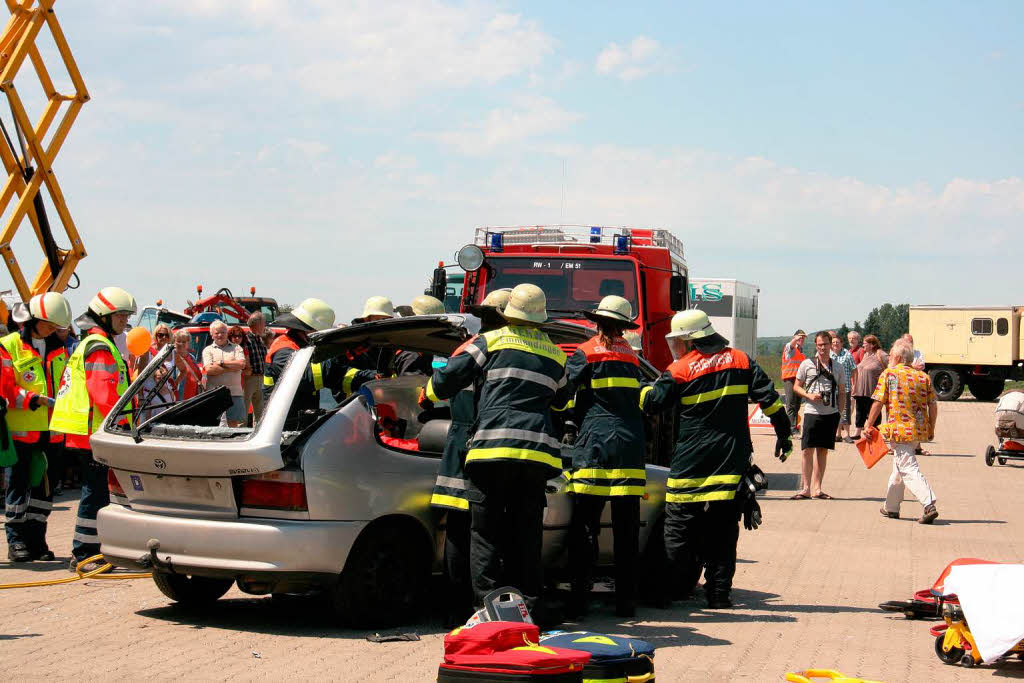Rettungsaktionen von Feuerwehr und Leitstelle des DRK bei einem simulierten Verkehrsunfall. Das Autodach wird abgehoben