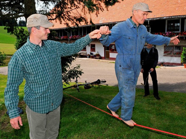 Thomas Dold (links) hilft dem Schauspieler Peter Schell auf der Slackline.  | Foto: dpa