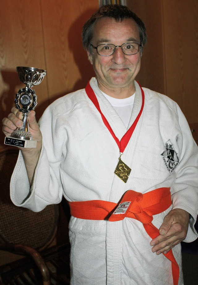 Judoka Gnther Hirsch zeigt stolz Poka...Goldmedaille von den Special Olympics.  | Foto: Hannah Klusmann