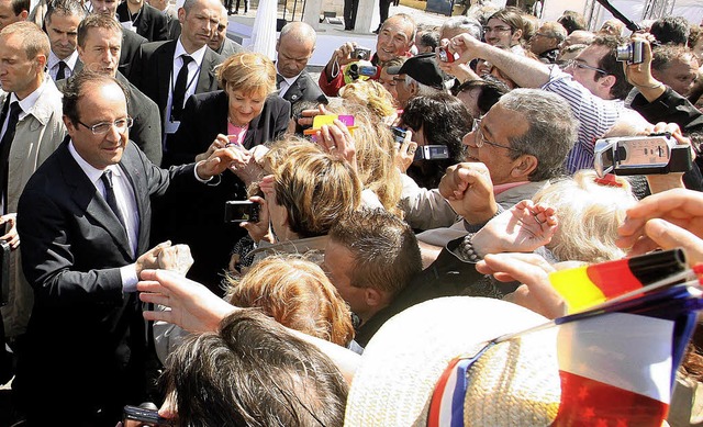 Franois Hollande und Angela Merkel schtteln Besuchern der Feiern die Hnde.   | Foto: AFP