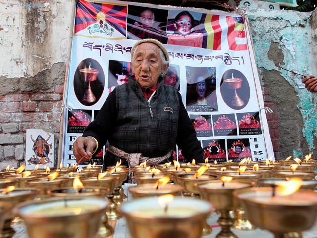 Eine Frau zndet Gebetskerzen im Gedenken an Tibet an.  