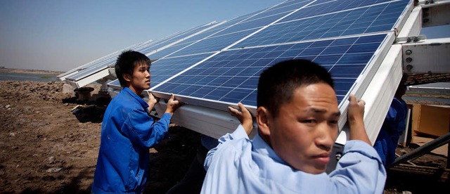 Solare Offensive:  Arbeiter installier...n Hafenstadt Tianjin  Solarpanele. AFP  | Foto: AFP ImageForum