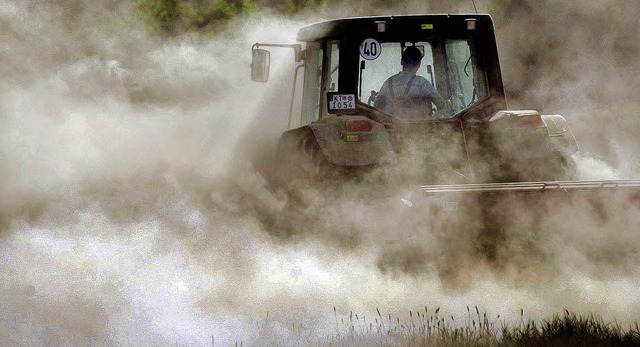 Ein Landwirt fhrt mit seinem Traktor ...anken und st  Rapssamen in die Erde.   | Foto: dpa