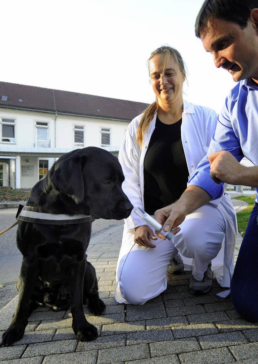 Hundeführer Uwe Friedrich (rechts) läs...obe eines Lungenpatienten schnüffeln.   | Foto: dpa