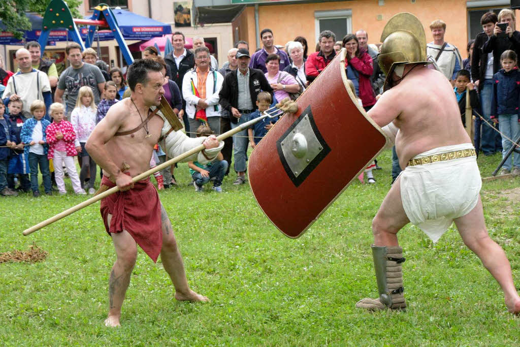 Kampfeskunst: Gladiatoren in Aktion vor groem Publikum.