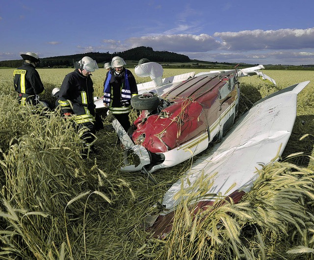 Feuerwehrmnner begutachten das abgestrzte Flugzeug im Kornfeld.    | Foto: DPA