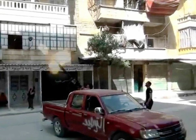 Aleppo: Ein Mann feuert Schsse von de...Beschuss von Assads Regierungstruppen.  | Foto: dpa